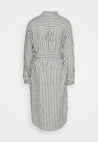 Abito camicia in lino a righe bianche e nere, con colletto, maniche lunghe e cintura in vita. Presenta righe verticali e polsini a bottoni.