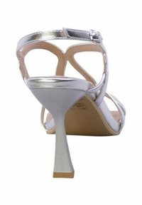Sandalino argentato con tacco alto, cinturini metallici, design aperto sul retro, tacco sottile, soletta beige, stile minimalista con cinturino alla caviglia regolabile.