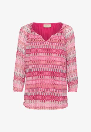 Blusa de color rosa con un diseño estampado, cuello en V, mangas largas y dobladillos elásticos. Presenta líneas onduladas en tonos de rosa, rojo y azul. Textura de tela suave.
