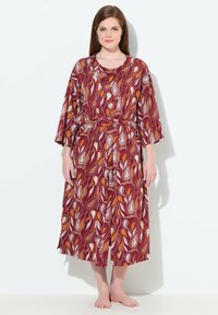 Dlouhé šaty s červeným a bílým vzorem, širokými rukávy, úzkým pasem a splývavým siluetou. Materiál má hladkou texturu, ideální pro pohodlí.