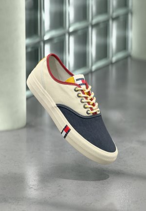 Lässiger Sneaker in niedriger Ausführung mit navyblauer Spitze, cremefarbenen Seiten, rotem Besatz, weißen Schnürsenkeln und Tommy Jeans-Logo auf Zunge und Sohle.