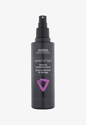 Bottiglia spray nera con tasto a pompa. L'etichetta frontale presenta testo bianco e un triangolo di accento viola. Contiene spray acceleratore per asciugatura.