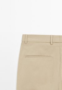 Beige cotton trousers with a straight cut, featuring a back pocket and belt loops. Smooth texture and minimalistic design.