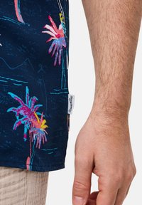 Marine shirt met levendige palmbomenprint in roze, blauw en geel. Heeft een gestikte label op de zoom en een zachte, gestructureerde stof.