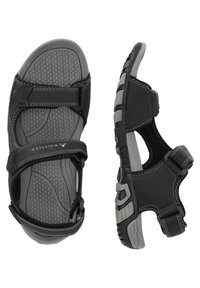 Mustat sandaalit harmailla yksityiskohdilla, joissa on säädettävät hihnat, teksturoitu pohja ja kestävä ulkopohja pitoa ja mukavuutta varten.