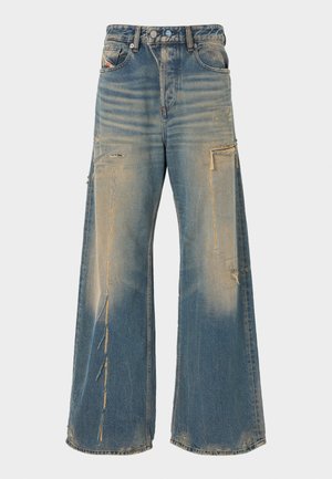 Jean en denim bleu à jambes larges avec des zones délavées et usées ainsi que des détails effilochés sur les cuisses et les genoux, poches avant visibles.