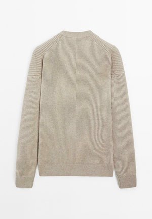 Beige geribbelde gebreide trui met lange mouwen, ronde hals en strakke manchetten, gezien vanaf de achterkant op een witte achtergrond.