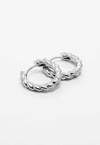 Silverfärgade hoopörhängen med flätad design, med en polerad yta och ett gångjärnsstängning. Rund form med strukturerade detaljer.
