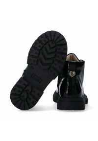 Stivaletti neri in vernice con suola in gomma testurizzata e decorazione a forma di cuore in oro sul tacco. Presentano una chiusura con zip sul lato.