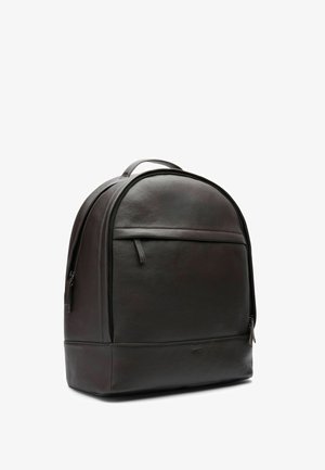 Sac à dos en cuir noir avec sommet arrondi, poche avant zippée, fermeture éclair latérale et poignée de transport supérieure sur fond blanc.