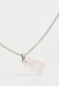Collar de cadena de plata con un colgante de oso de goma rosa que tiene un acabado brillante y detalles redondeados.
