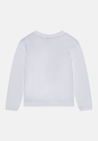 Vit långärmad skjorta med rund halsringning och ribbade ärmslut. Tillverkad av ett slätt tyg, med en sömlös baksidesdesign utan synliga etiketter.