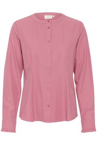 Blouse rose à manches longues avec un col rond, des boutons à l'avant et des poignets volantés. Tissu lisse avec un design ajusté et un bas évasé.