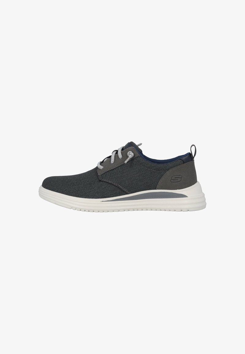 Baskets en textile gris avec des lacets gris clair, une semelle blanche et un accent bleu marine au talon. Présentent un design simple et une tige texturée.