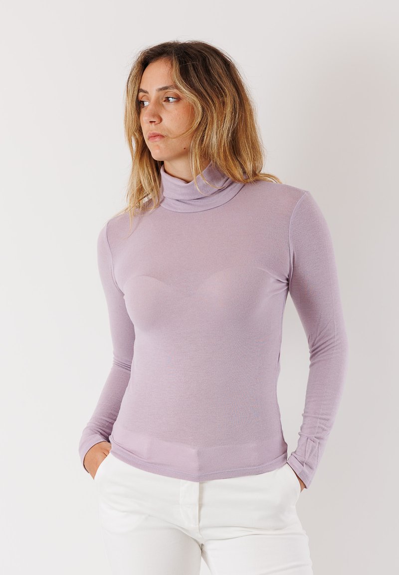 Maglia a maniche lunghe a dolcevita di un delicato colore lavanda, realizzata in tessuto morbido ed elasticizzato. Presenta una silhouette aderente e un design con colletto alto.