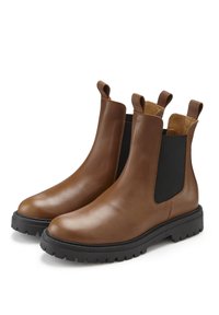 Brown leather Chelsea boots with elastic side panels, pull tabs, and a black chunky rubber sole. Smooth texture with a rounded toe.
