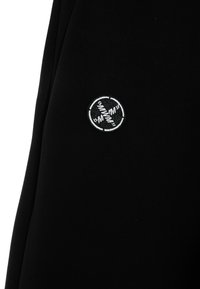 Sudadera negra hecha de una tela suave, con un logo bordado en blanco en forma circular en el lado izquierdo. El diseño es simple, con mínimas embellishments.