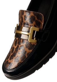 Loafer shoe with glossy black trim, leopard print upper, and gold rectangular metal buckle detail on white background.