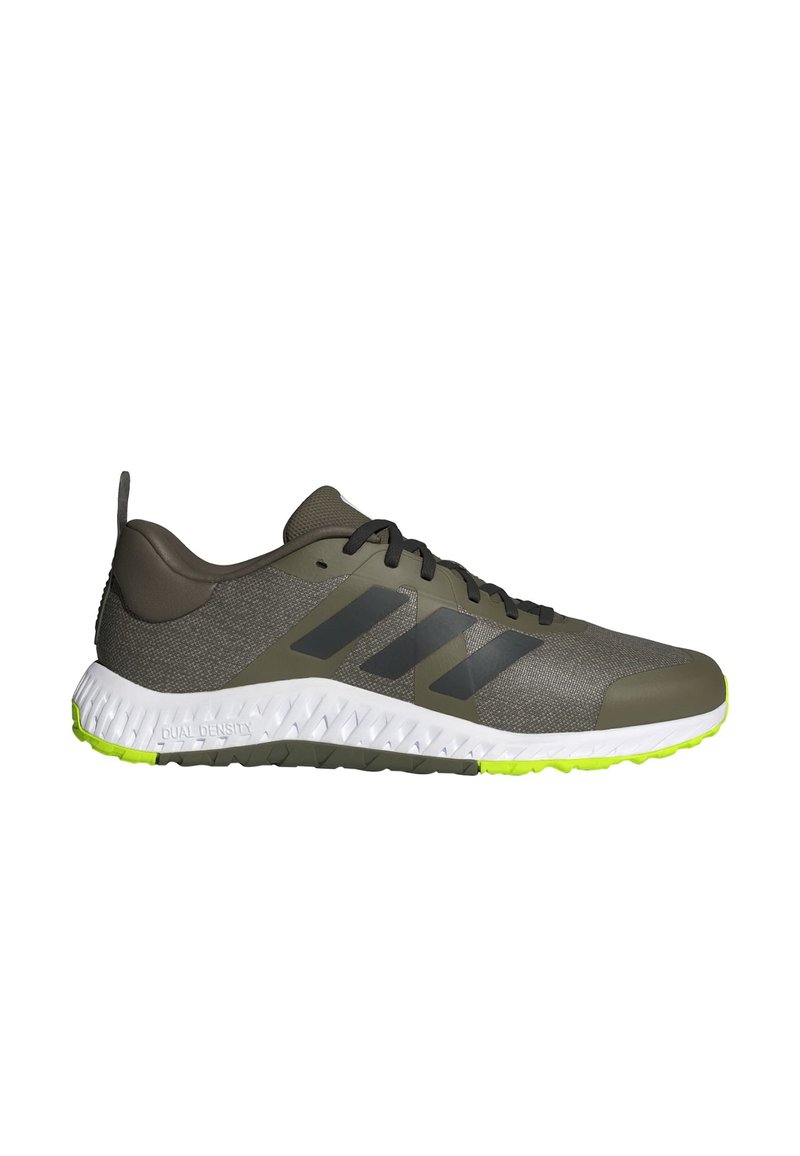 Sportliche Schuhe mit einem grauen Mesh-Obermaterial, schwarzen Akzenten, Gummisohle und leuchtend grüner Außensohle. Verfügt über eine strukturierte Oberfläche und ein Logo-Design.