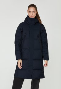 Abrigo largo acolchado de color azul marino con un alto cuello, bolsillos laterales con cremallera y un diseño elegante y aerodinámico. Fabricado con un tejido suave y cálido.