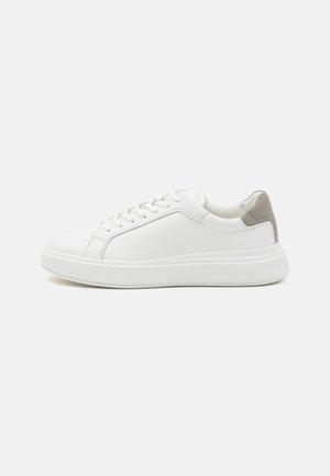 Hvit sneaker med en glatt lær overdel, grå hæltab, solid såle og snøringssystem, med minimal søm og et rent design.