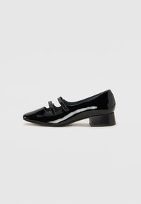 Black patent leather shoe with a pointed toe, low block heel, and three decorative straps across the front. Smooth, shiny texture.
