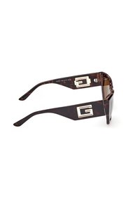 Zonnebril met inchroommotief en brede armen met zilveren geometrische "G"-logo's aan beide zijden.