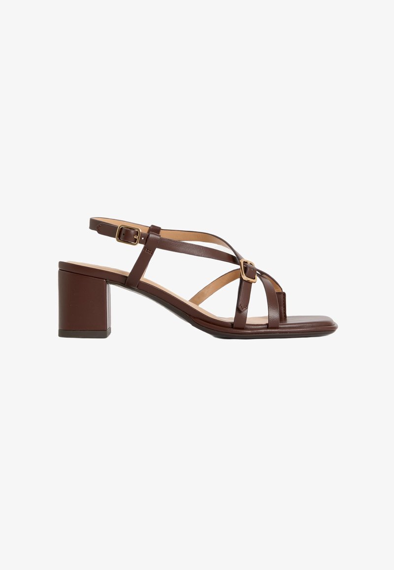Bruna läderklackad sandal med fyrkantig tå, flera korslagda remmar och justerbar ankelrem med detaljer i guldton.