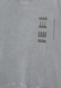 Harmaa collegepaita pehmeästä kankaasta. Edessä on tummanharmaalla painettu teksti. Pyöreä pääntie ja resorit hihansuissa.