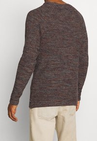 Strickpullover aus braunem und grauem strukturiertem Stoff, mit langen Ärmeln und Rundhalsausschnitt, sowie einem leicht verlängerten hinteren Saum.