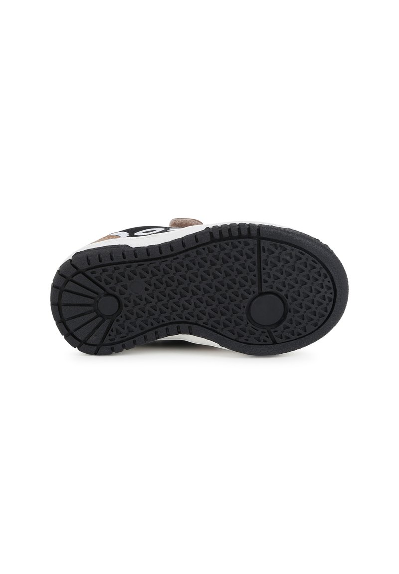 Suela de zapato con un caucho negro texturizado, un medallón circular, bordes reforzados y un patrón de pequeños rombos.