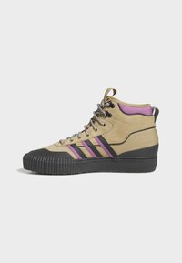 Höga sneakers i beige canvas med lila och svarta ränder. Har en текстurerad gummisul och grå snören. Liten hälflik bak.