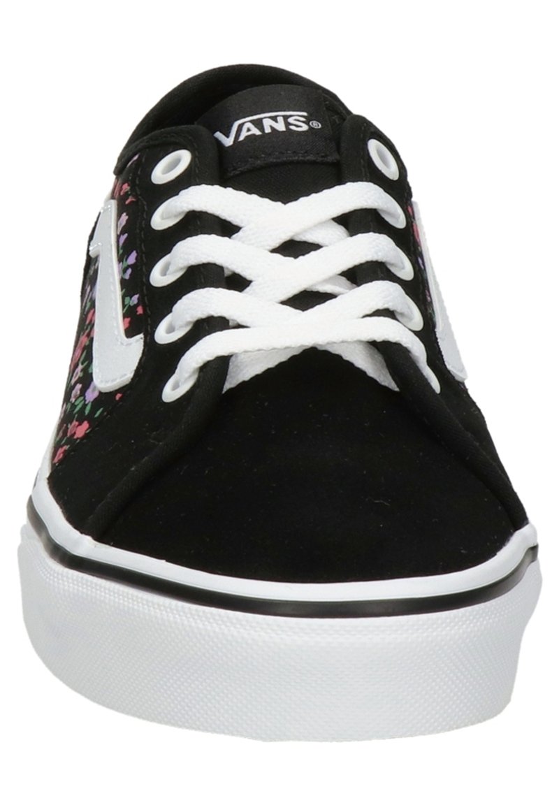 Zapatillas de lona negras con cordones blancos, que presentan patrones florales coloridos en los laterales y una suela de goma blanca con acentos negros.