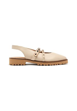 Scarpe slingback beige con punta arrotondata, suola piatta e dettagli borchiati sulle cinghie. Texture liscia e design minimalista.