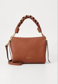 Ruda tekstūruota odinė rankinė su pintu rankena, auksinės spalvos apdaila ir nuimamu petnešos diržu. Ant jos yra reljefinis prekės ženklo logotipas.