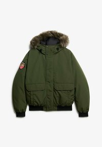 Green padded jacket with a faux fur hood, front zip closure, two large patch pockets, and ribbed cuffs. Features an embroidered badge on the arm.
