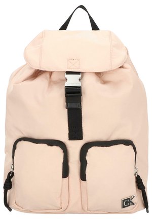 Zaino rosa chiaro con patta, tracolla nera regolabile, accessori in argento e due tasche anteriori bordate in tessuto nero. Logo Calvin Klein in evidenza.