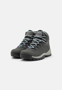 Gray hiking boots with a textured surface, reinforced toe, and mesh accents. Features blue laces and rugged rubber soles for grip.