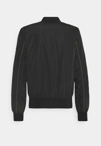 Veste bomber noire avec une texture lisse, poignets et ourlet côtelés, présentant des coutures jaunes le long des seams. Le design est classique et polyvalent.