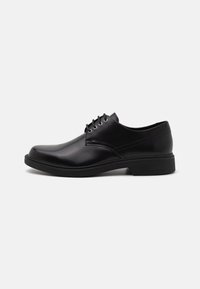Chaussure habillée en cuir noir avec une finition brillante, dotée d'un bout arrondi, de six œillets et d'un petit talon. Design simple avec des accents minimaux.