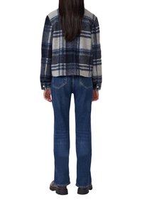 Geruite flanellen jas in grijs en marineblauw, cropped ontwerp, gecombineerd met donkerblauwe denim jeans in rechte pasvorm met zichtbare stiksels.