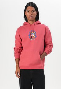 Rode hoodie van zachte stof, met een centraal grafisch ontwerp met blauwe accenten. Voorzak in kangoeroestijl en een capuchon met koord.