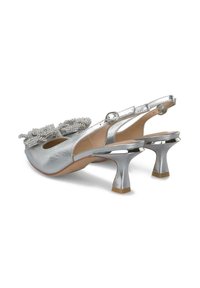 Tacchi slingback metallici argento con un fiocco testurizzato e dettagli in perline, dotati di un tacco a blocco di media altezza e una punta arrotondata elegante.