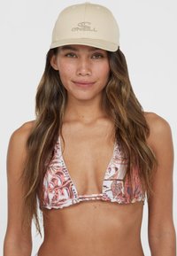 Tans baseball cap med broderet logo; livligt mønstret bikini i nuancer af pink og hvid; trekantet snit, justerbare stropper og flæser.