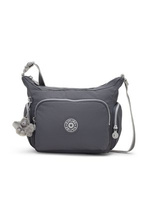 Sac bandoulière gris foncé avec plusieurs poches zippées, sangle réglable, logo rond Kipling, et un petit porte-clés singe en peluche attaché.