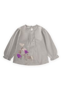 Siva bluza s dugim rukavima i okruglim izrezom, s naboranim prednjim dijelom i napuhanim rukavima. Sadrži vezene cvjetove u ljubičastim i ružičastim nijansama.