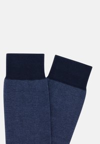 Calzini blu navy con polsini a costine, caratterizzati da un motivo tessuto a trama. Il materiale sembra morbido ed elastico, adatto per un indossamento confortevole.