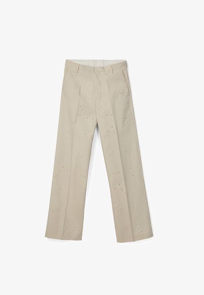 Pantalones beige de pierna recta con cintura alta, trabillas para cinturón, bolsillos laterales y un pequeño patrón disperso de manchas negras.