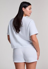 Gestreepte lounge set in lichtblauw en wit. Bevat een t-shirt met korte mouwen en bijpassende shorts van zachte, gestructureerde stof met een ontspannen pasvorm.