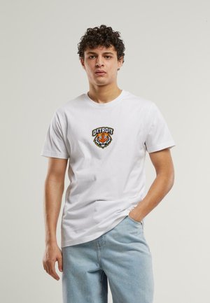 Witte katoenen T-shirt met een geborduurde oranje tijger en de tekst "DETROIT" op de borst. Korte mouwen en een ronde hals.